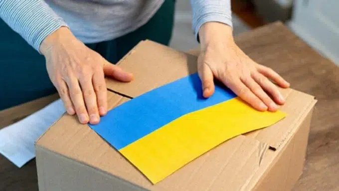 Woman packing box with flag of Ukraine on top