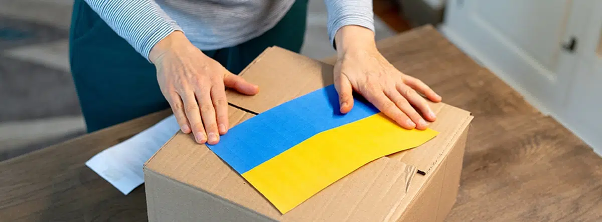 Woman packing box with flag of Ukraine on top