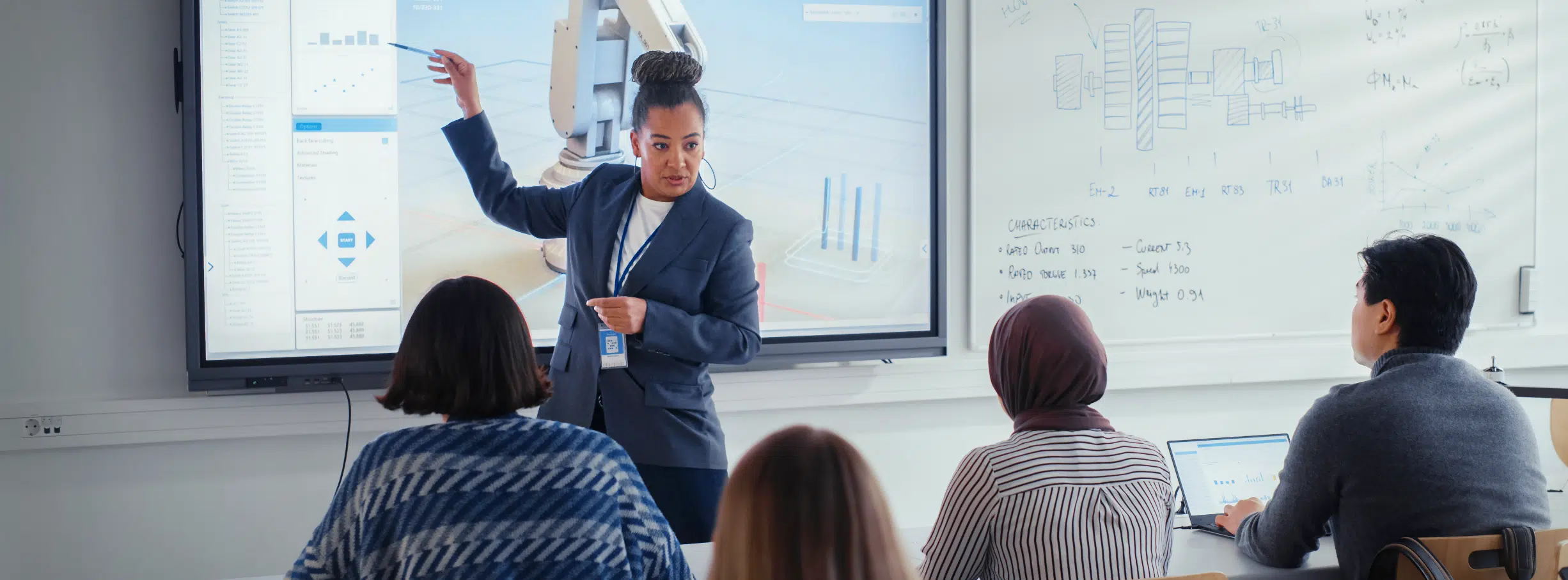 Banner image depicting a female teacher showing a projection of a computer screen to her college class.