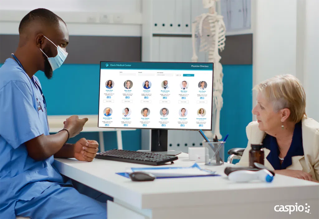 Young male nurse shows a list of doctors to an elderly female patient. 